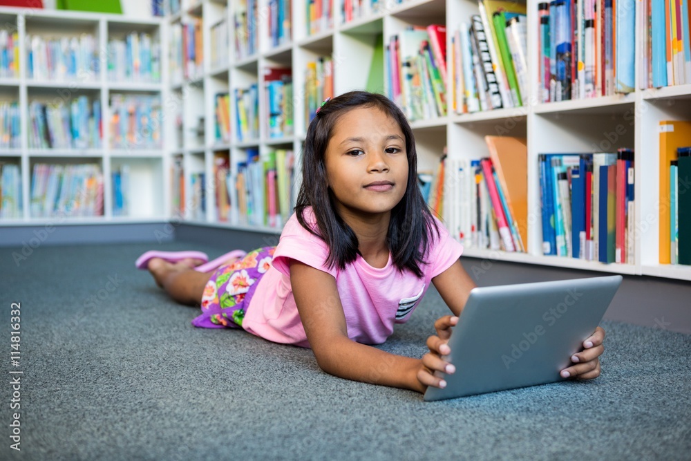 Girl holding digital tablet in school library Girl holding digital tablet in school library