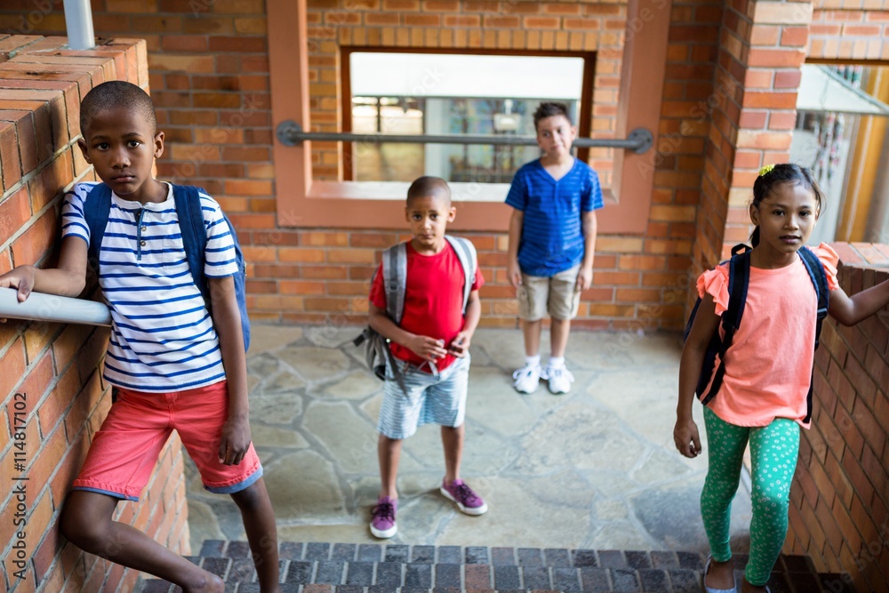 Obraz premium Classmates standing at school corridor