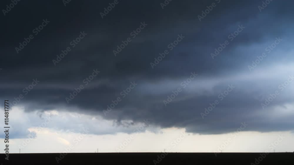 Dark time-lapse storm clouds, ragged beneath, rotate over the prairie Dark time-lapse storm clouds, ragged beneath, rotate over the prairie