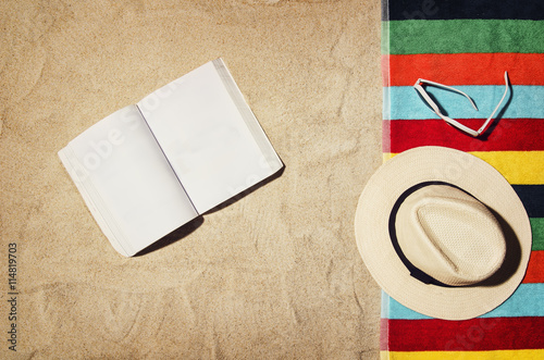 Top view of sandy beach with summer accessories and copy space around products. Blank mock up for blog, advertising or packaging. photo