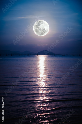 Romantic scenic with full moon on sea to night. Reflection of moon in water. 