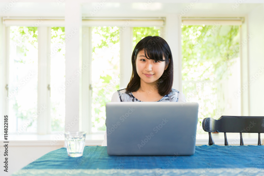 部屋でパソコンを使う女性
