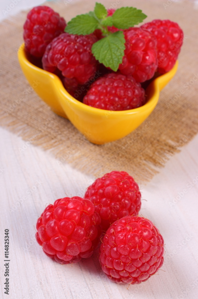 Fresh raspberries and lemon balm on white wooden table, healthy food Fresh raspberries and lemon balm on white wooden table, healthy food