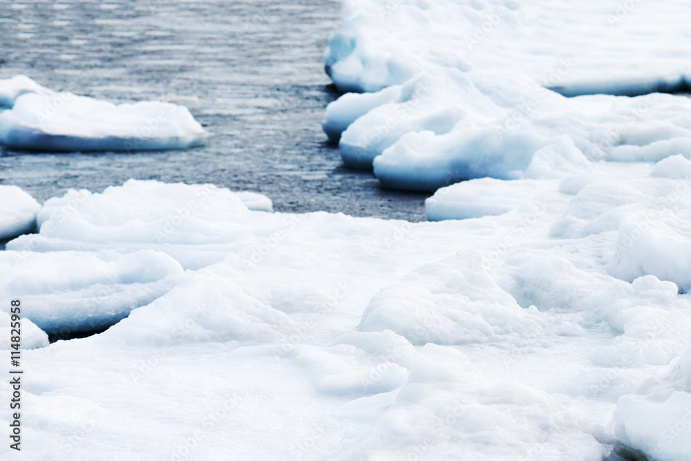 Natural sea ice blocks breaking up against shore. .