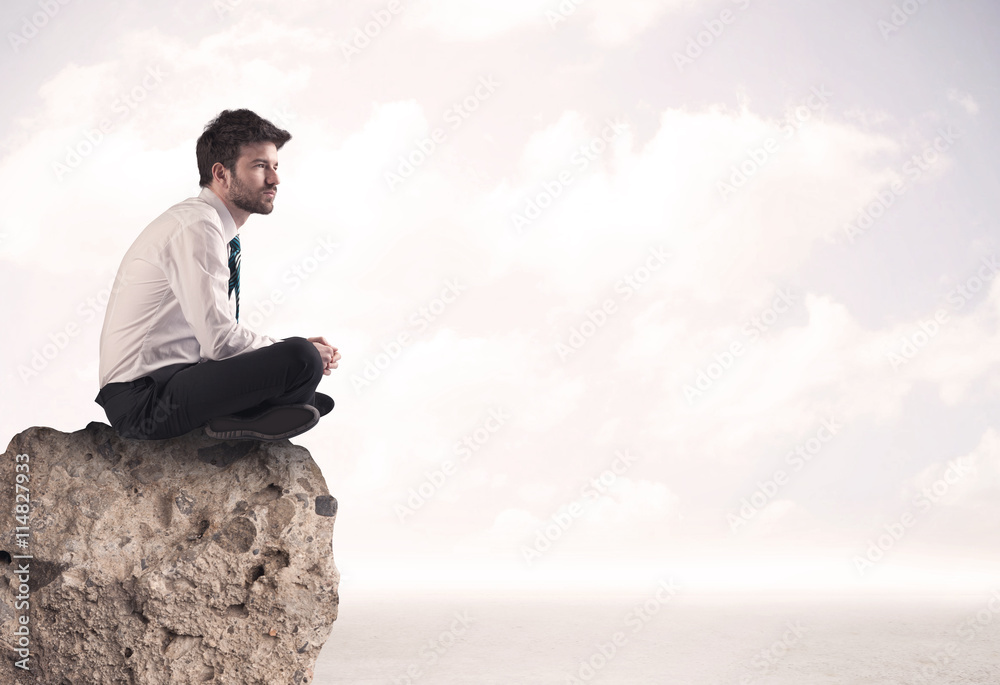 Business man sitting on stone edge