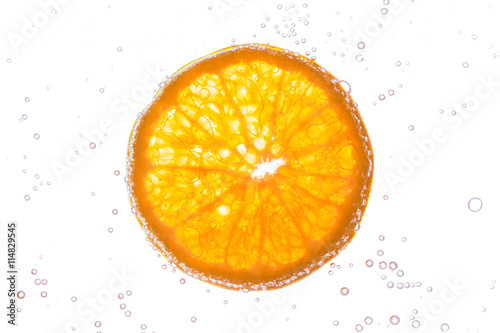 Fresh orange slice in water with bubbles on white background