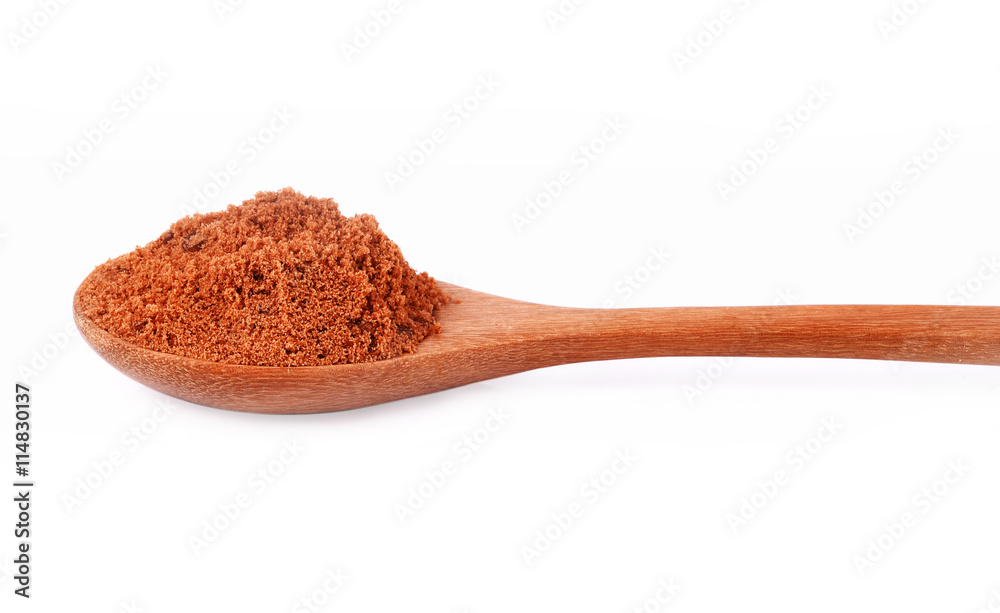 Natural browh sugar in spoon on white background Natural browh sugar in spoon on white background
