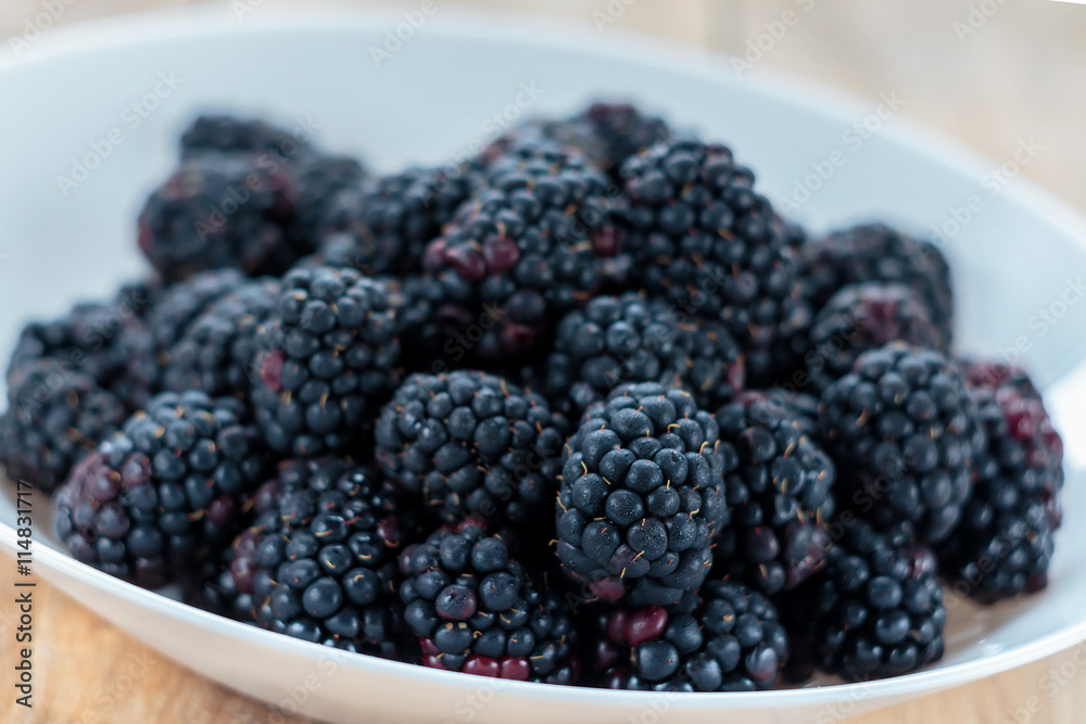 Fresh ripe blackberries in white bowl, shallow depth of field Fresh ripe blackberries in white bowl, shallow depth of field