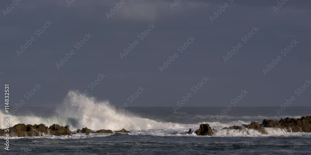 Foaming waves exploding above a rocky reef Foaming waves exploding above a rocky reef