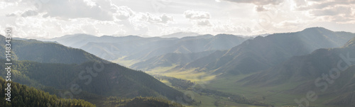 Mountain valley in the rays of the midday sun and fog