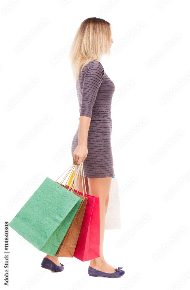 back view of going  woman  with shopping bags