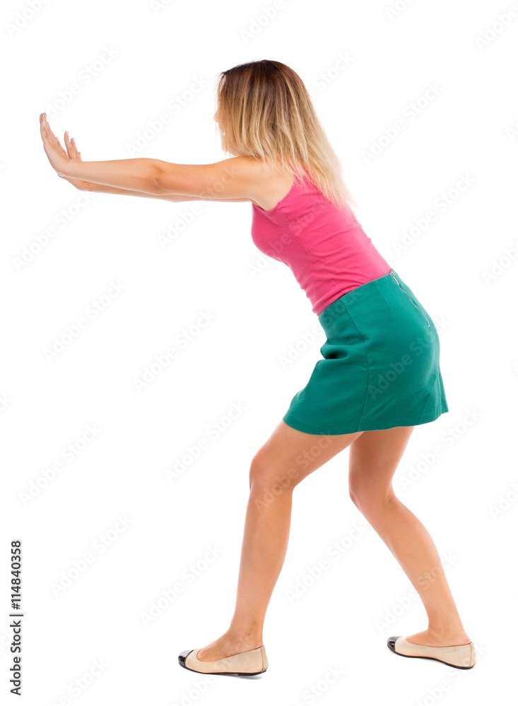 back view of woman pushes wall.