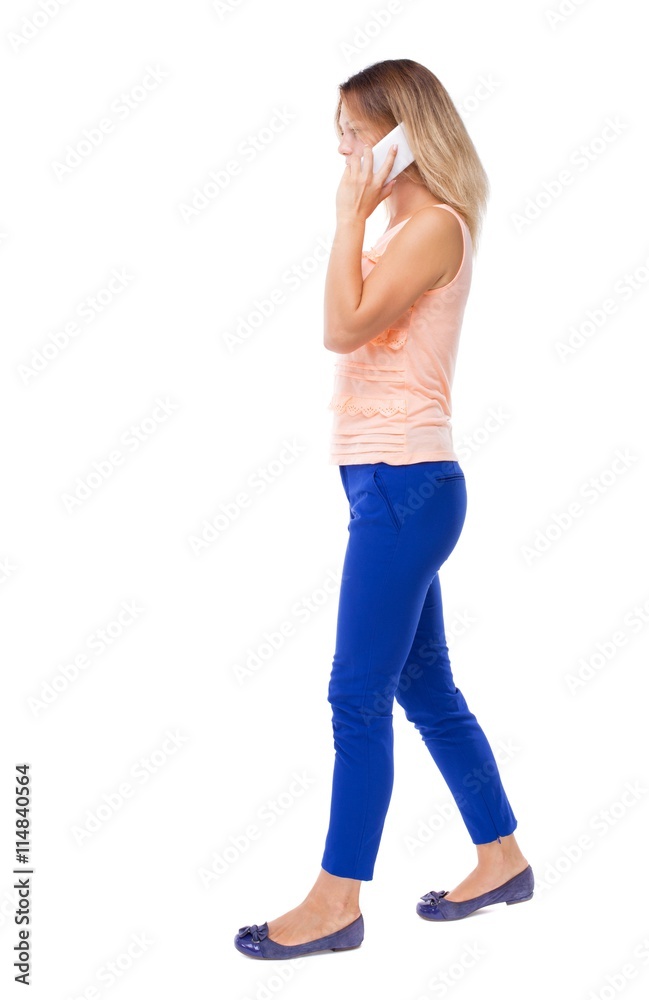 side view of a woman walking with a mobile phone. back view ofgi side view of a woman walking with a mobile phone. back view ofgi