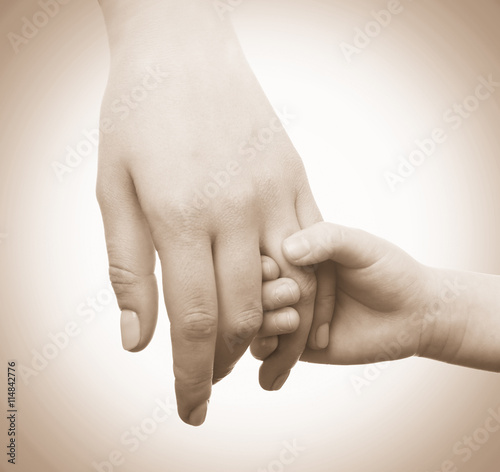 Child and mother hands together on light background