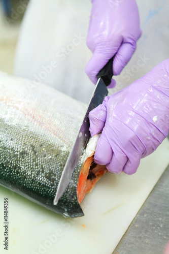 Close up of men cutting salmon fish in fish industry