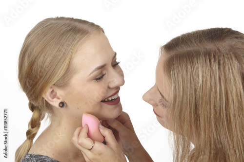 Sie benutzt einen Kosmetikschwamm bei ihrer Freundin