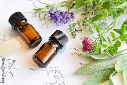 Quadro su tela essential oils with herbs on science sheet
