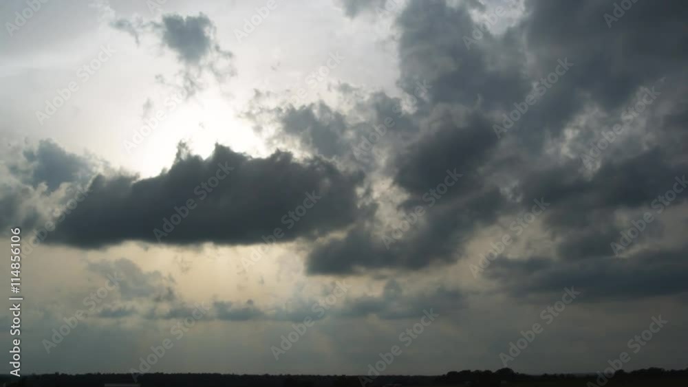 Winds blowing from different directions and at different heights move clouds across sunlit sky, time lapse Winds blowing from different directions and at different heights move clouds across sunlit sky, time lapse