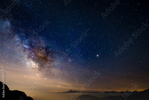 The colorful glowing core of the Milky Way and the starry sky captured at high altitude in summertime on the Italian Alps, Torino Province. Mars and Saturn glowing mid frame. photo