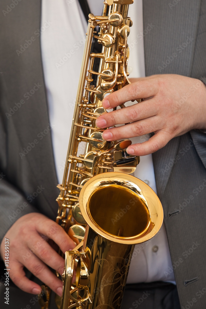 Obraz premium Saxophone musician in his hands closeup