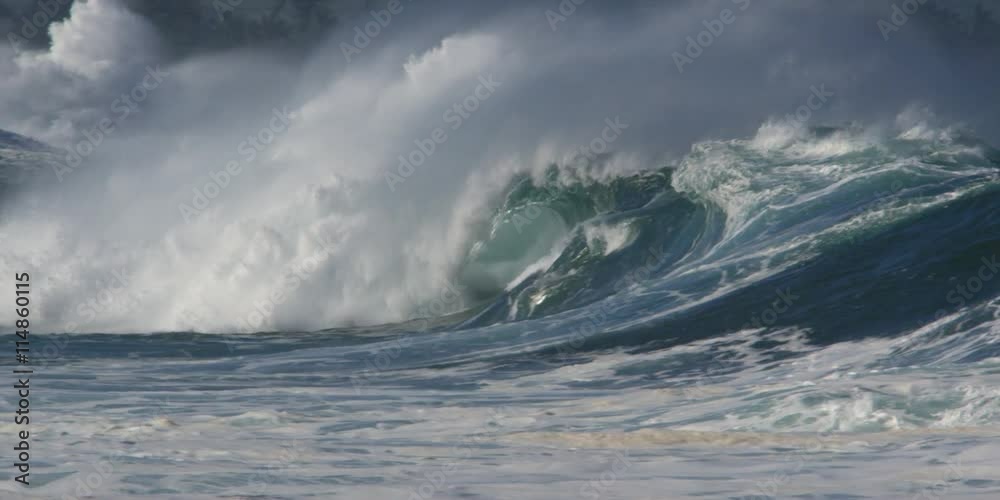 Foaming waves dashing against dark rocks near shoreline houses Foaming waves dashing against dark rocks near shoreline houses