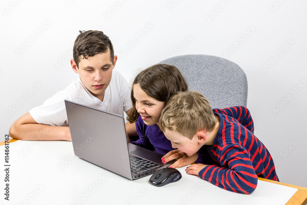 Two boys and one girl using laptop together, learning and study together. 