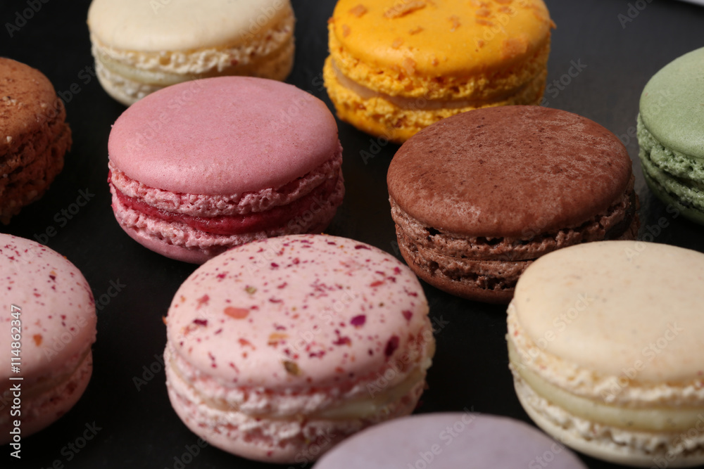 Sweet and colourful french macaroons on black  background