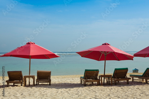 Lounge chairs with sun umbrella on a beach  Bali  Indonesia