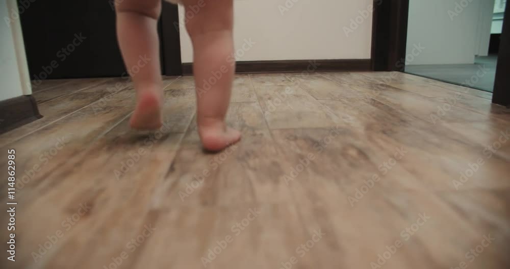 Close-up of baby boy walking his first steps,slow motion Close-up of baby boy walking his first steps,slow motion