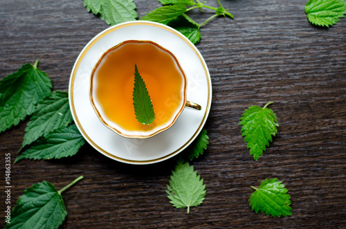 herbal nettle tea in a porcelain Cup on a dark wooden background