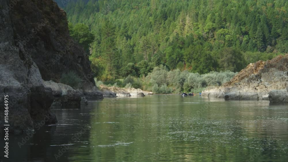 Drifting past canyon walls toward a forested hillside on the Rogue River, Oregon Drifting past canyon walls toward a forested hillside on the Rogue River, Oregon