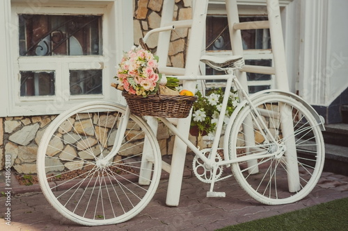white vintage bicycle with a wedding bouquet in a basket