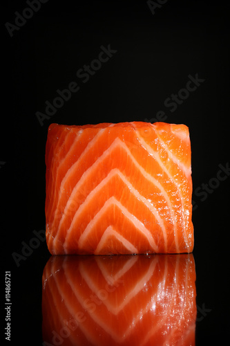 Fresh salmon piece isolated on black background with reflection 