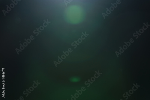 real green lens flare over dark background