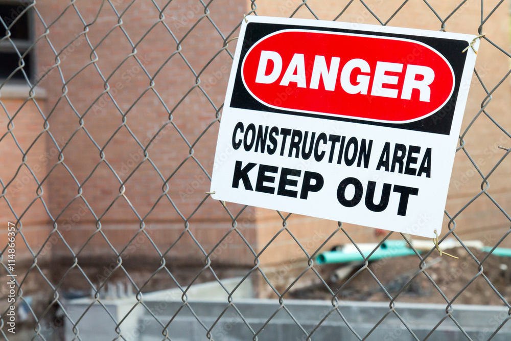 Danger construction area keep out sign in front of an addition