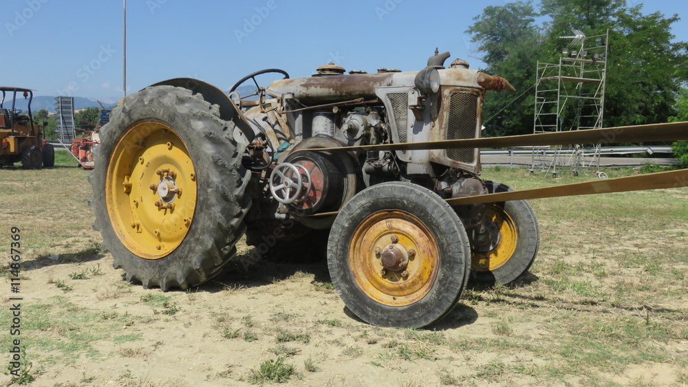 Old wheeled tractor used for threshing Old wheeled tractor used for threshing