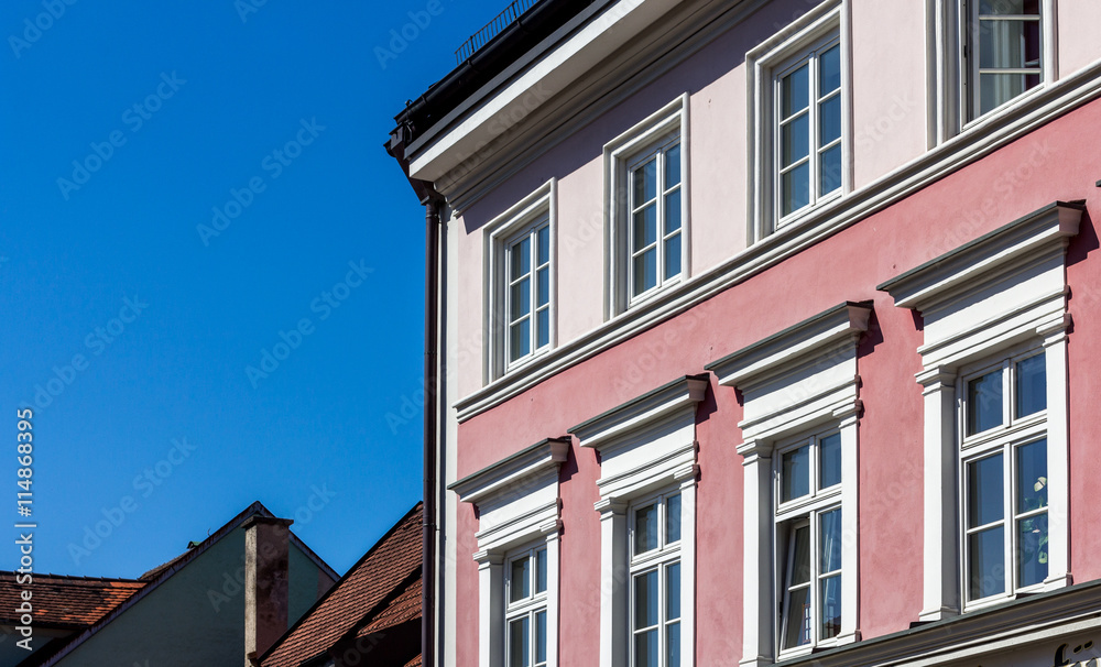 Bayrische Altbau - Häuserfassade mit Fenstern in bunten Farben vor Blauem Himmel