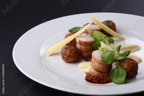 Baked meat rabbit roll and rissole with chees, souses on white plate. Close up