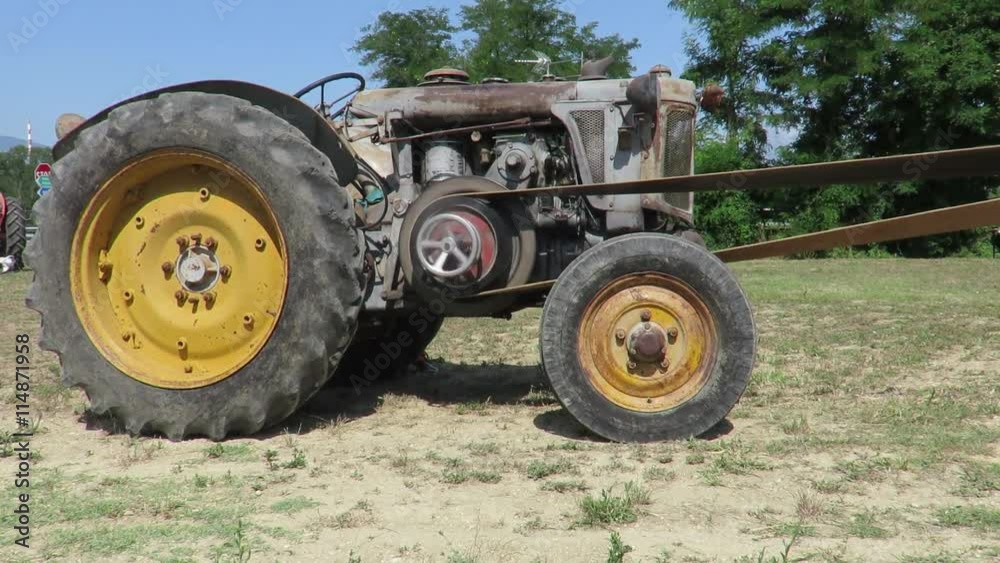 Old wheeled tractor used for threshing Old wheeled tractor used for threshing