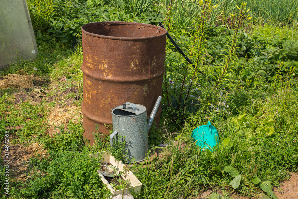 watering pot and barrel of water in the garden