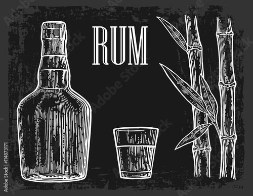 Glass and bottle of rum with sugar cane.