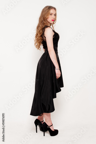 Portrait of beautiful young blonde girl in black dress. Fashion photo