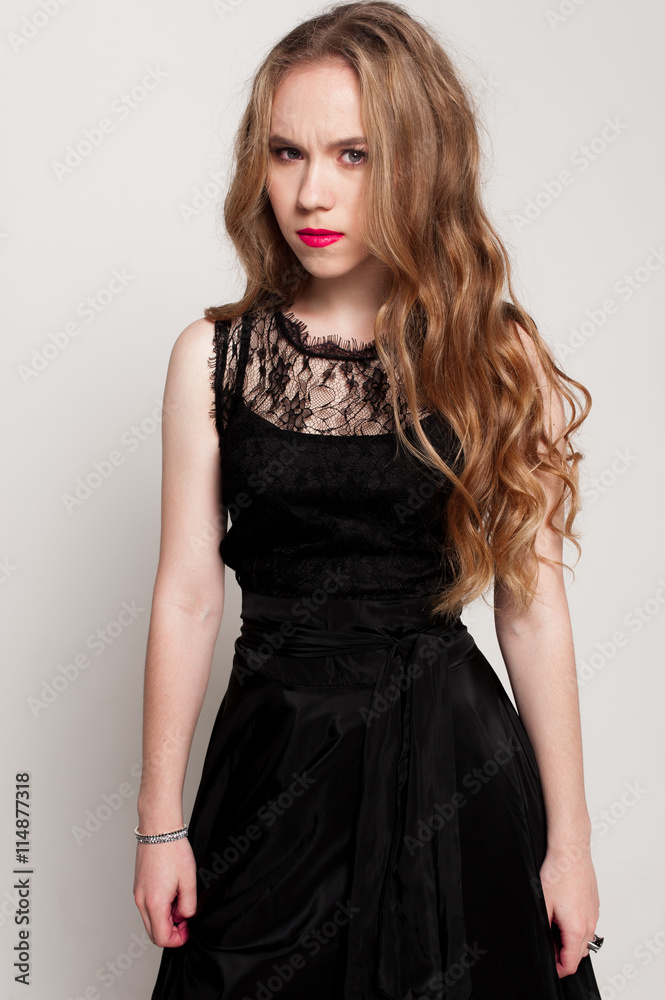 Portrait of beautiful young blonde girl in black dress. Fashion photo Portrait of beautiful young blonde girl in black dress. Fashion photo