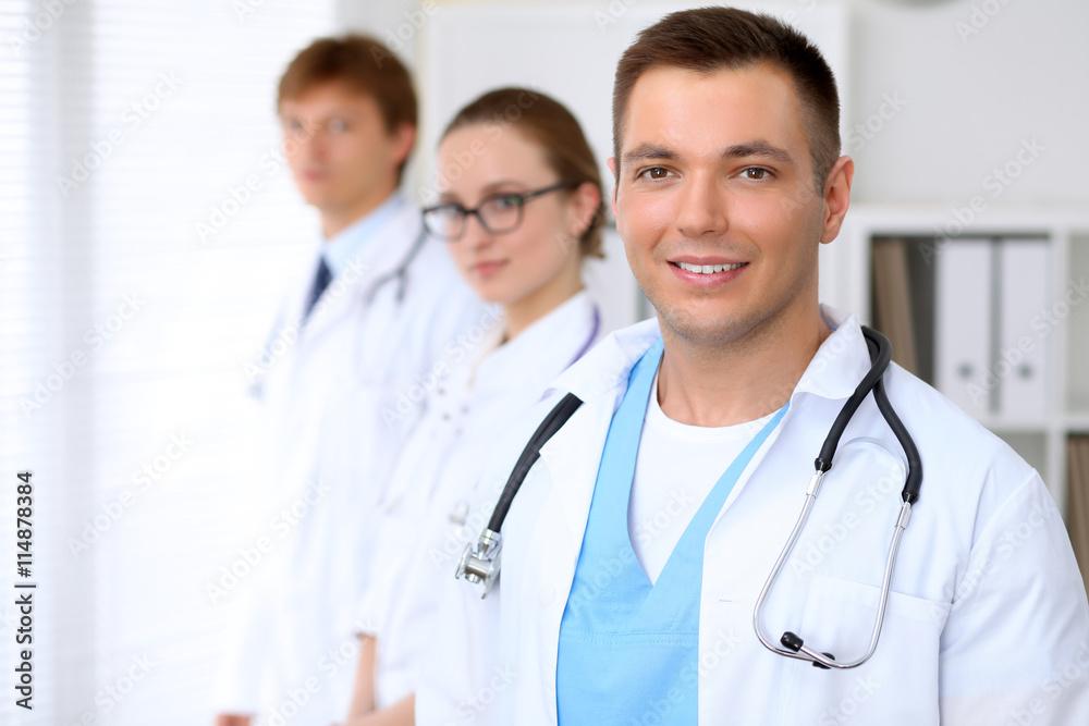 Cheerful smiling male doctor with medical staff at the hospital Cheerful smiling male doctor with medical staff at the hospital