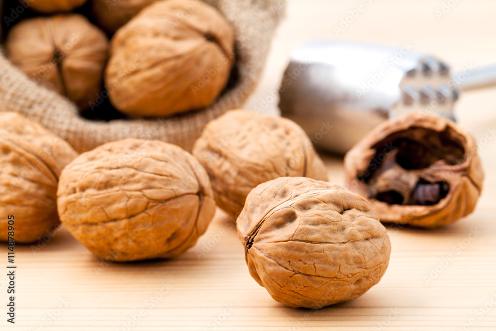 Walnuts kernels and whole walnuts on wooden background. Whole an