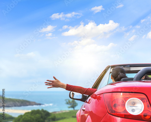 Girl in a red convertible car.