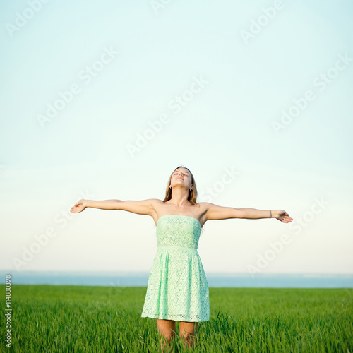 Happiness woman stay outdoor under sunlight of sunset. With raised hands at the sunrise time.