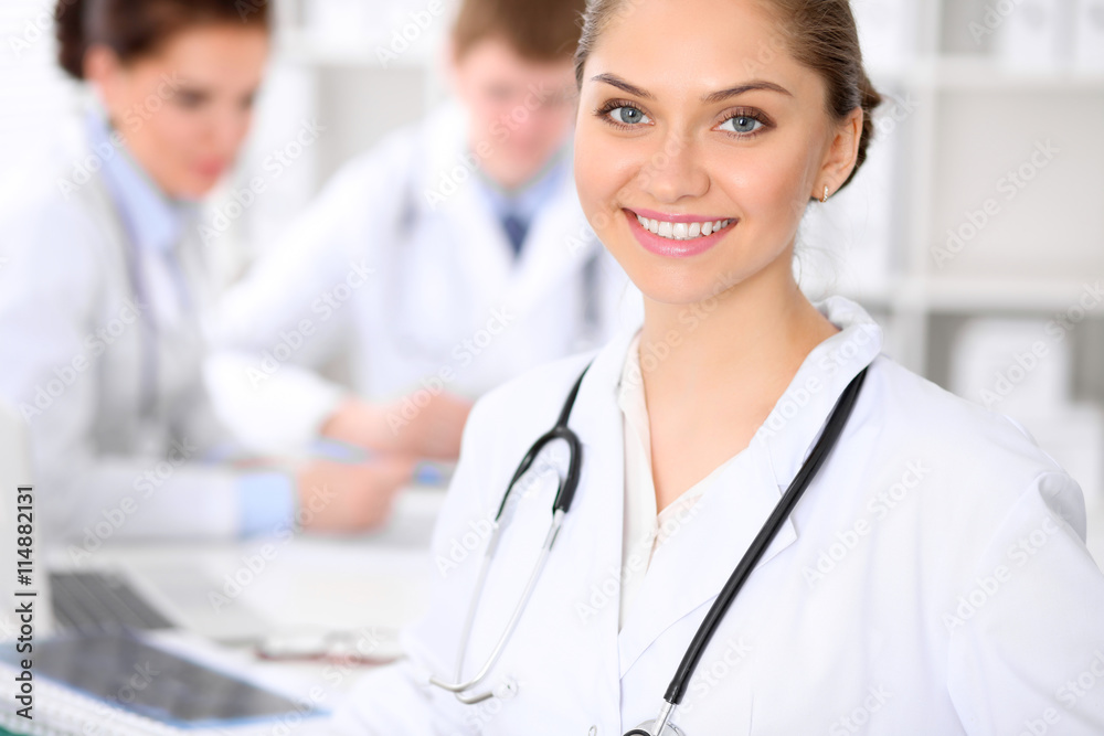 Happy doctor woman with medical staff at the hospital sitting at the table and discussing medical history Happy doctor woman with medical staff at the hospital sitting at the table and discussing medical history