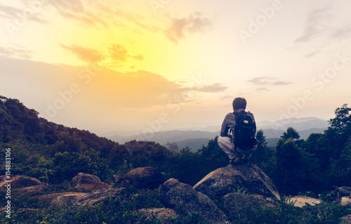 Freedom traveler siitng on rock and enjoying a beautiful nature