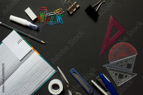 Top view of office supplies on black background
